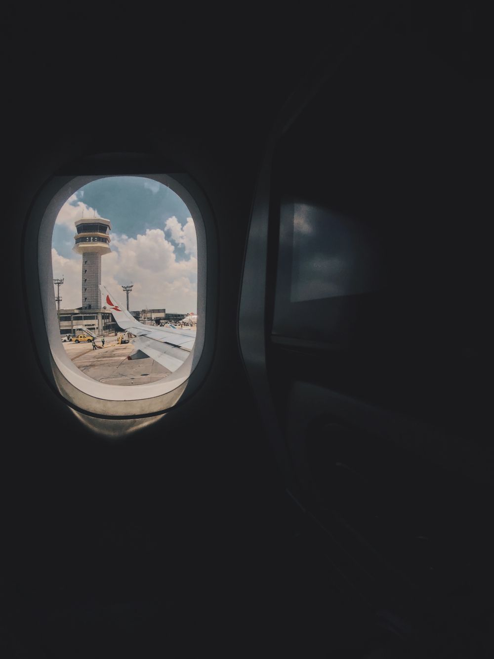 Vista da janela do avião com a torre de controle do aeroporto